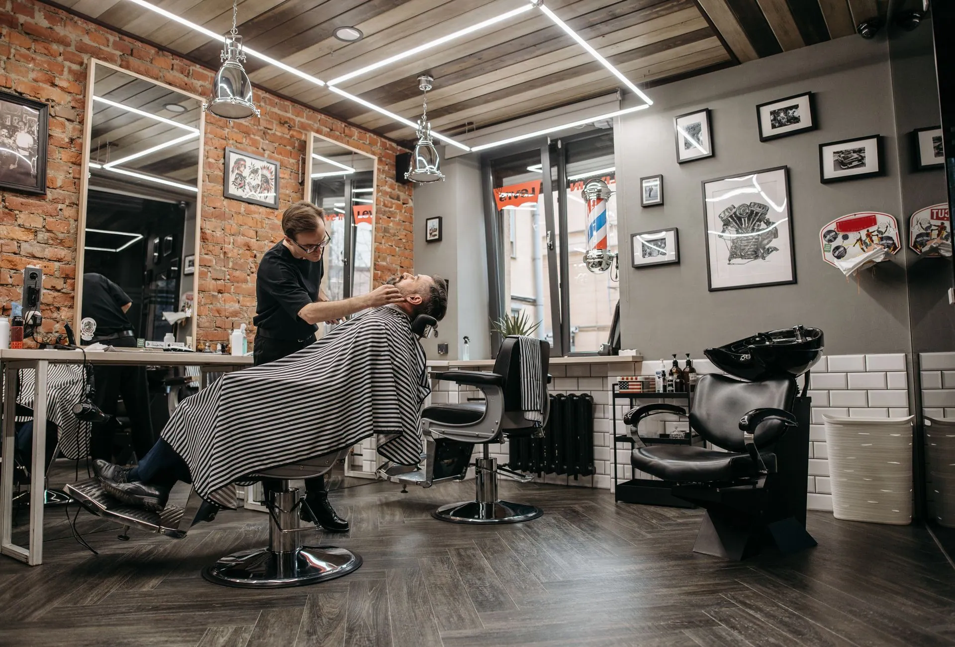 Barbeiro fazendo a barba de um cliente na cadeira
